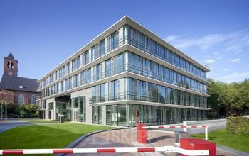 Modern office building exterior at De Cuserstraat 91, Amsterdam Buitenveldert, showcasing sleek glass façade and green surroundings, perfect for office space rental.