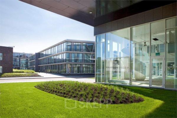 Exterior view of contemporary office building at De Cuserstraat 85, Amsterdam Buitenveldert, showcasing modern architecture and well-maintained green spaces, available for office space rental.