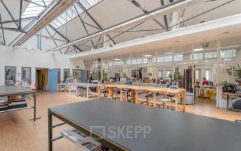 Spacious office space rental at Oudeschans 21, Amsterdam Center, with large windows and modern worktables for a collaborative environment.