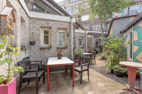Inviting courtyard office space rental at Oudeschans 21, Amsterdam Center, with outdoor seating and lush potted plants.