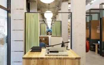 Modern office space rental at Vijzelstraat 68-78, Amsterdam Center, with a welcoming reception desk and cozy workspaces in the background.