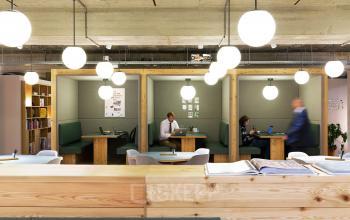 Modern office interior at Vijzelstraat 68-78, Amsterdam Center with cozy workspaces and people engaged in business activities.