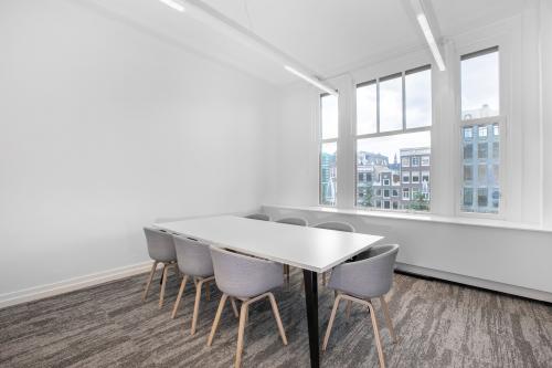 Bright office space at Rokin 92-96, Amsterdam Center with modern chairs and large windows, ideal for office space rental.