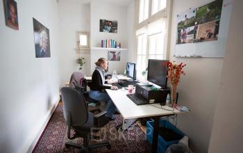 Office space rental in Schippersgracht 1-3, Amsterdam Center featuring a workspace with desks, computers, and personal decor.