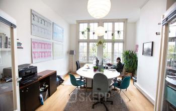Workspaces with a round table and chairs in an office located at Schippersgracht 1-3, Amsterdam Center, Amsterdam, available for office space rental.