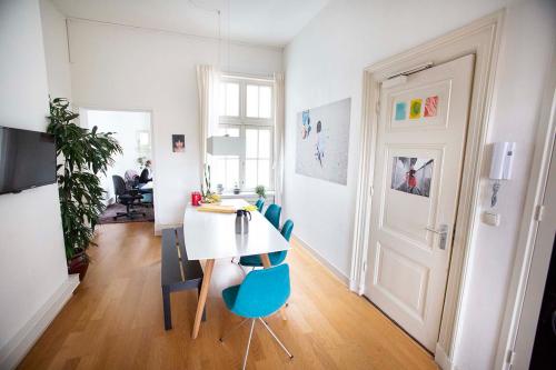 Modern office space for rent at Schippersgracht 1-3, Amsterdam Center; features stylish wooden flooring, a conference table, artwork on the walls, and a person working at a desk in the background.