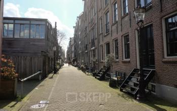 Exterior view of the office location at Prinseneiland 23A, Amsterdam Center, showcasing a charming canal-side street ideal for an office space rental.