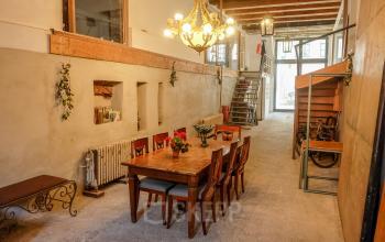 Charming office space with wooden beams and a chandelier at Prinseneiland 23A, Amsterdam Center, ideal for office space rental. Features a long table with chairs perfect for meetings.