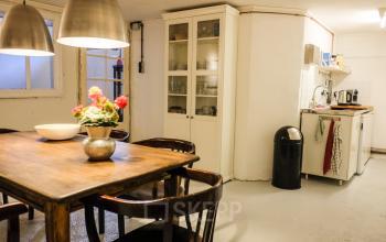 Cozy office space for rent at Prinseneiland 23A, Amsterdam Center, featuring a furnished area with a table and chairs, suitable for small meetings or team gatherings.