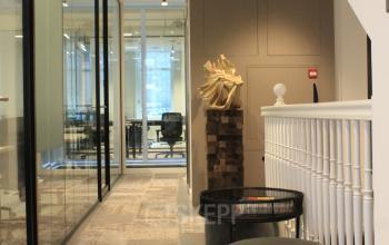 Interior of an Amsterdam Center office at Hekelveld 8-10 featuring modern workspaces with stylish decor including seating and a statue. Ideal for office space rental.