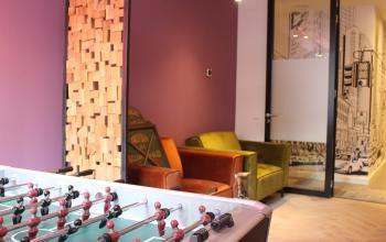Contemporary Amsterdam Center office space rental at Hekelveld 8-10 featuring a foosball table and stylish lounge area.