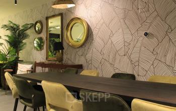 Stylish office in Amsterdam Center at Hekelveld 8-10 with a long table, mirrors, and plants, ideal for workspaces. Discover office space rental in a vibrant setting.