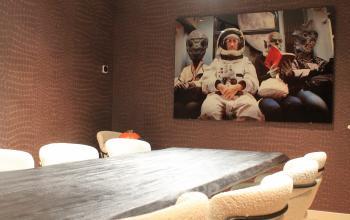 Stylish conference room with textured walls and a unique space-themed artwork, located at Hekelveld 8-10, Amsterdam Center, ideal for those seeking office space rental.