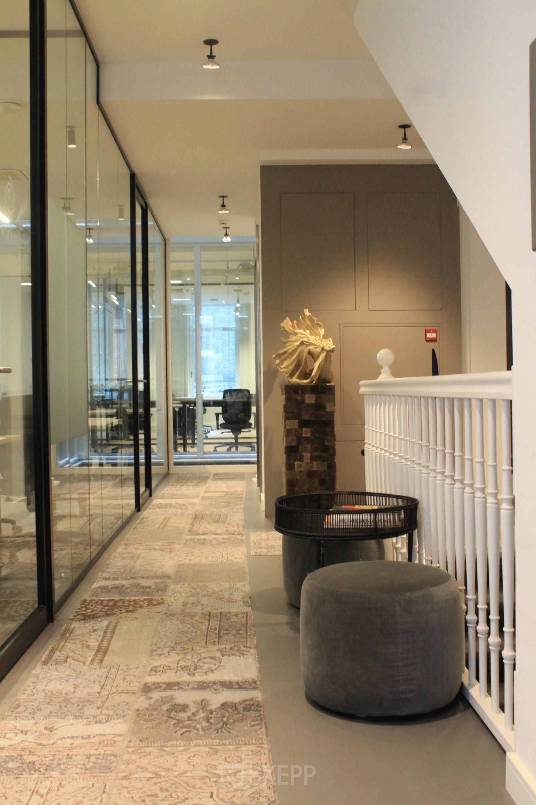 Interior of an Amsterdam Center office at Hekelveld 8-10 featuring modern workspaces with stylish decor including seating and a statue. Ideal for office space rental.