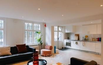 Interior office space at Westeinde 14-16, Amsterdam Center, featuring cozy seating, a modern kitchen area, and bright windows, offering appealing office space rental options.