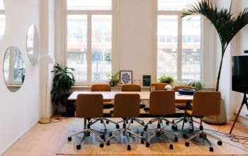 Bright meeting room with a long table and chairs, ample natural light, and modern decor at Westeinde 14-16, ideal for office space rental in Amsterdam Center.