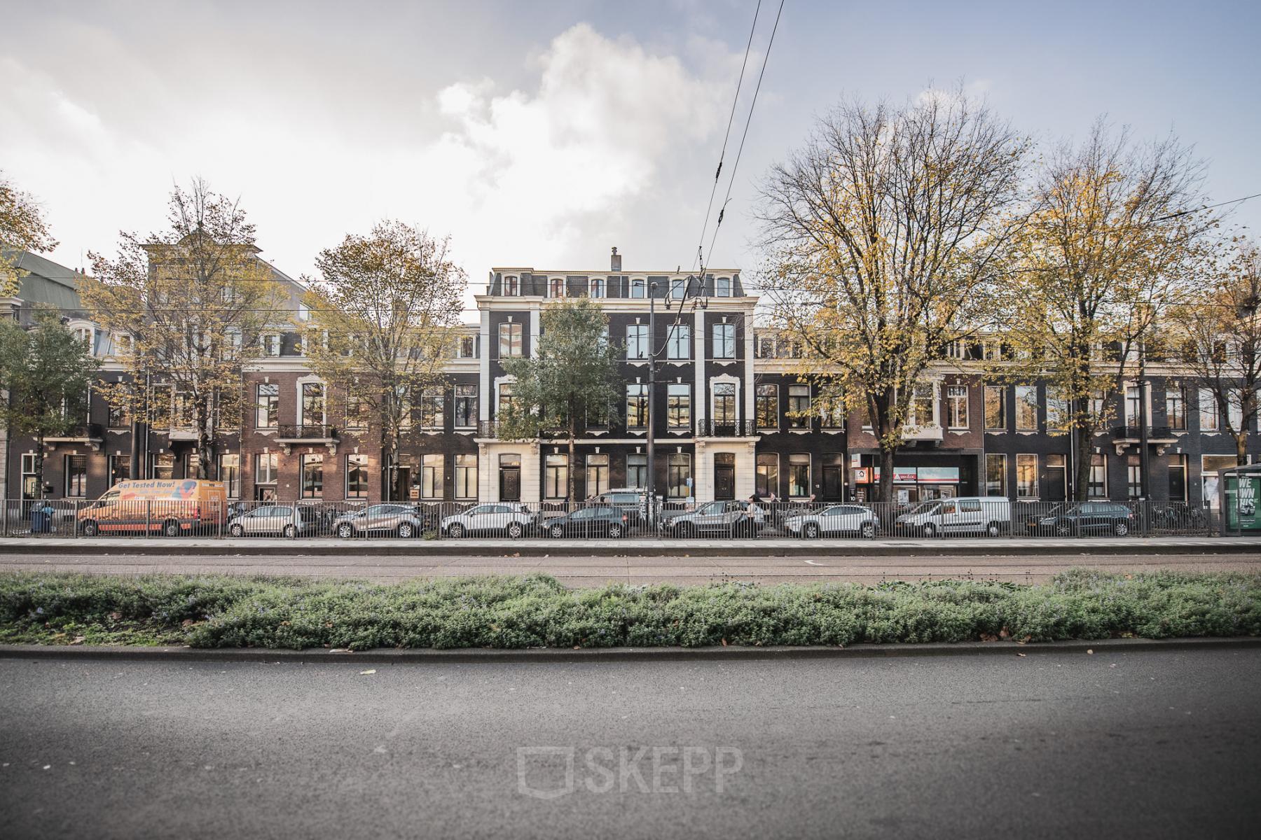Street view of office buildings at Westeinde 14-16, Amsterdam Center, with multiple cars parked along the sidewalk.