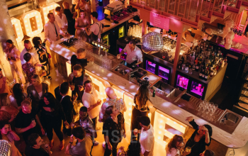 A lively event space at Weesperplein 4b, Amsterdam Center, with people enjoying a party atmosphere, making it ideal for informal gatherings. Consider this vibrant location for an alternative office to rent.