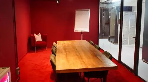 A furnished conference room with a large wooden table and seven chairs, located at Weesperplein 4b, Amsterdam Center. Ideal for office space rental or finding an office to rent.