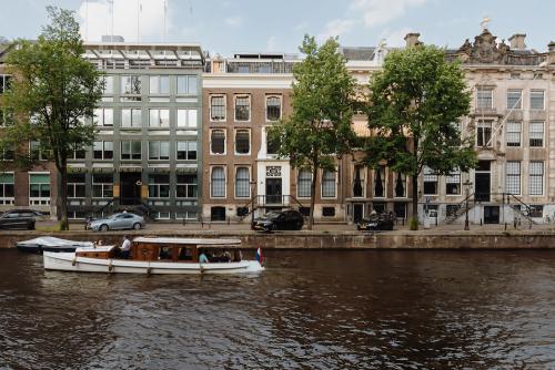 Exterior view of Herengracht 471, Amsterdam Center, showcasing canal-side offices available for rent. Historic buildings line the street, perfect for office space rental.
