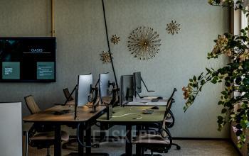 Modern office space rental at Stationsplein 9 in Amsterdam Center with desks, chairs, and monitors in a well-decorated room.