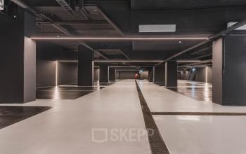 Spacious, modern parking area with sleek black ceilings and polished concrete floors at Weesperstraat 107-121 in Amsterdam Center, ideal for those looking for office space rental with convenient parking options.