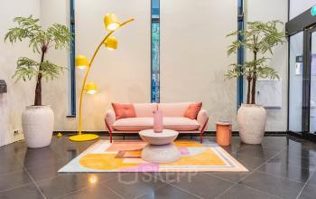 Chic lounge area at Weesperstraat 107-121, Amsterdam, featuring modern furnishings, vibrant decor, and ample seating. Ideal for office space rental with a welcoming atmosphere for meetings or relaxation.