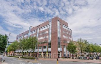 Exterior view of office building located at Weesperstraat 107-121 in Amsterdam Center. Large, multi-story structure with modern design and ample windows for office space rental opportunities.