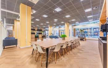 Spacious office space rental at Weesperstraat 107-121, Amsterdam Center, featuring modern furniture, large communal table, and ample natural light. Ideal for collaborative work and meetings.