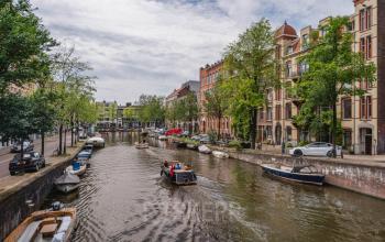 Scenic view of the canal-side historic buildings at Weesperstraat 107-121 in Amsterdam Center, ideal for an office space rental with charming architecture.