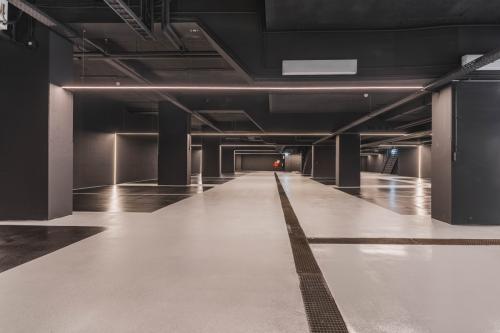 Spacious, modern parking area with sleek black ceilings and polished concrete floors at Weesperstraat 107-121 in Amsterdam Center, ideal for those looking for office space rental with convenient parking options.