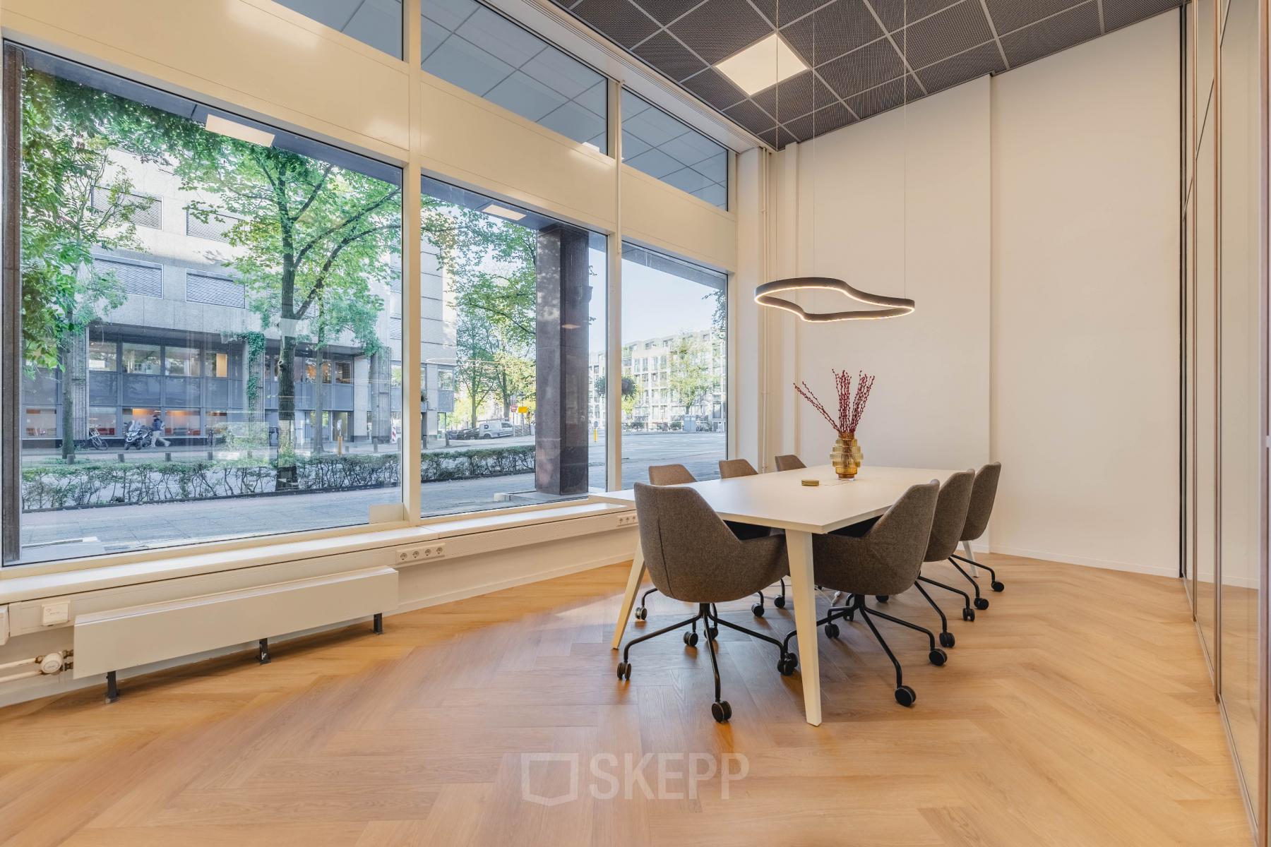 Bright conference room with large windows and modern furnishings at Weesperstraat 107-121, Amsterdam Center, ideal for office space rental.