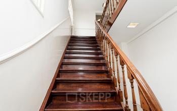 Wooden staircase with white walls and large windows in the office space rental at Keizersgracht 241, Amsterdam Center.