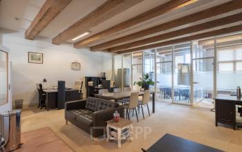 Well-appointed office space rental at Keizersgracht 241-2, Amsterdam Canal Belt, featuring modern desks and comfortable seating under exposed wooden beams.