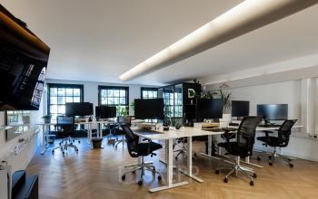 Modern workspace at Rokin 46-1, Amsterdam Center, featuring sleek desks, advanced computers, and ergonomic chairs, ideal for office space rental.