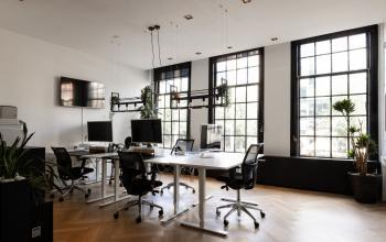 Spacious, well-lit office interior at Rokin 46-1, Amsterdam Center, featuring modern desks and large windows. Ideal office to rent with excellent natural light for an inspiring work atmosphere.