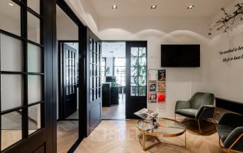 Modern office space rental at Rokin 46-1 in Amsterdam Center, featuring a stylish lounge area with sleek furnishings, natural light, and a welcoming atmosphere designed for relaxation and informal meetings.