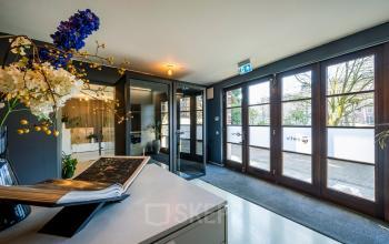 Bright entrance area at Groenmarktkade 5-H in Amsterdam Center, with large windows and modern decor, available for office space rental.