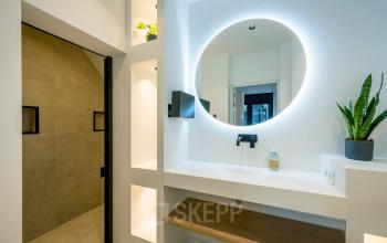 Modern office space at Groenmarktkade 5-H in Amsterdam featuring a sleek, minimalist wash area with ambient lighting and plants, perfect for office space rental seekers seeking a fresh environment.