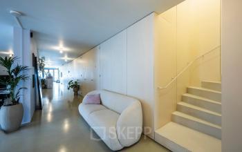 Modern office interior at Groenmarktkade 5-H, Amsterdam Center featuring sleek seating, potted plants, and minimalistic decor; ideal for office space rental with a welcoming atmosphere.