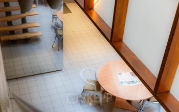 Interior view of a modern workspace at Kerkstraat 204, Amsterdam Center, featuring a wooden staircase and a round table with chairs, ideal for office space rental.