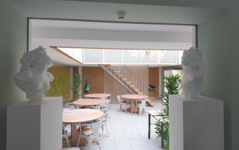 Spacious office area at Kerkstraat 204, Amsterdam Center, featuring round tables, chairs, and greenery ideal for office space rental.