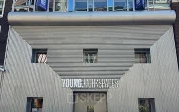 Exterior view of an office building for rent at Kerkstraat 204, Amsterdam Center, featuring a modern facade and bicycles parked outside.