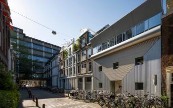 Exterior of the office building at Kerkstraat 204, Amsterdam Center, featuring modern architecture with large windows and surrounding bicycle parking. Ideal for those seeking office space rental in a vibrant location.