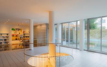 Spacious modern office interior at Kerkstraat 204, Amsterdam Center, featuring large windows, sleek tile flooring, and minimalistic design, perfect for office space rental.