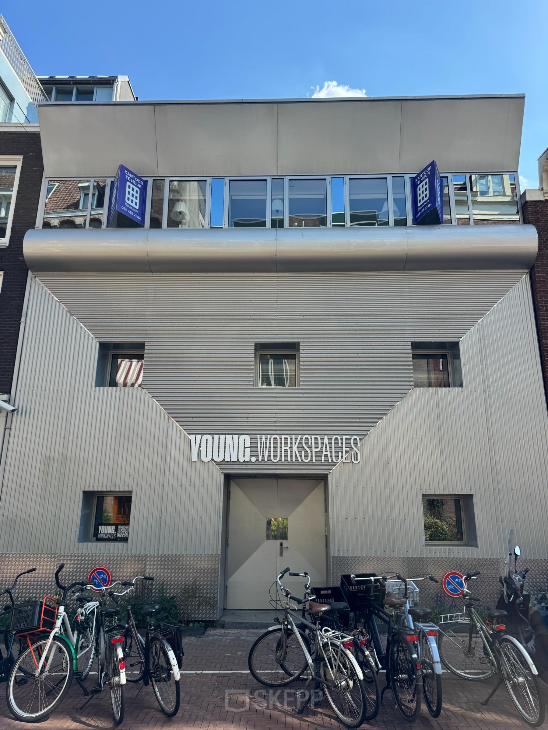 Exterior view of an office building for rent at Kerkstraat 204, Amsterdam Center, featuring a modern facade and bicycles parked outside.