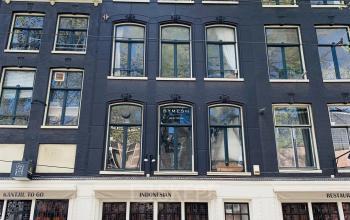 Exterior view of office building at Nieuwezijds Voorburgwal 340, Amsterdam Center. The historic façade features large windows and a charming traditional design, making it a prominent location for office space rental.