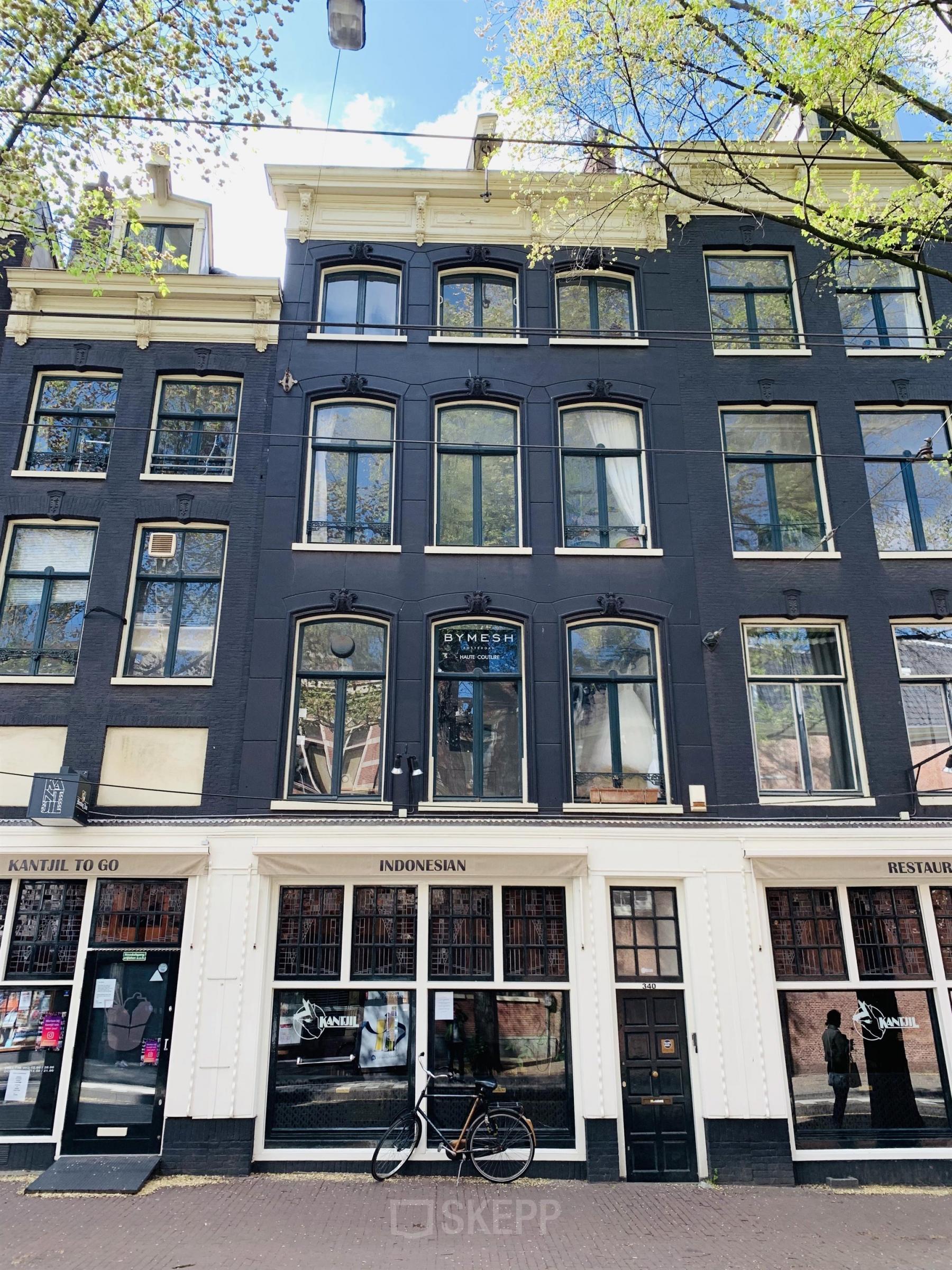 Exterior view of office building at Nieuwezijds Voorburgwal 340, Amsterdam Center. The historic façade features large windows and a charming traditional design, making it a prominent location for office space rental.