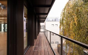 Exterior balcony view of office space rental at Pieter Cornelisz. Hooftstraat 7, Amsterdam Center, showcasing modern glass panels and a welcoming atmosphere.