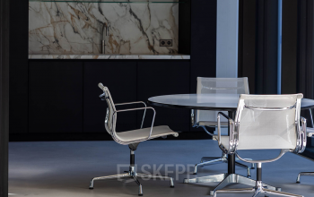 Modern office space with sleek furnishings and a stylish marble backdrop, ideal for rent office space in Amsterdam Center.